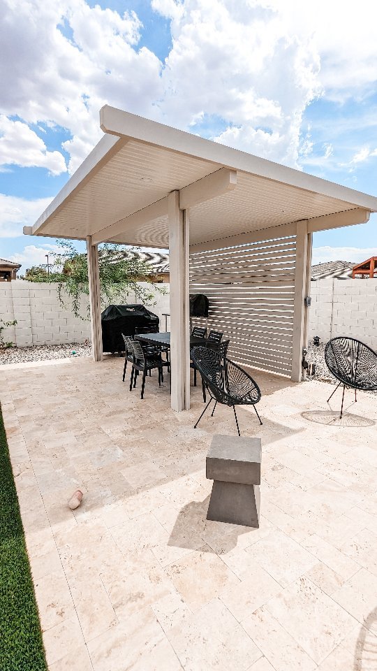 White flat-panel patio cover over a modern outdoor dining space
