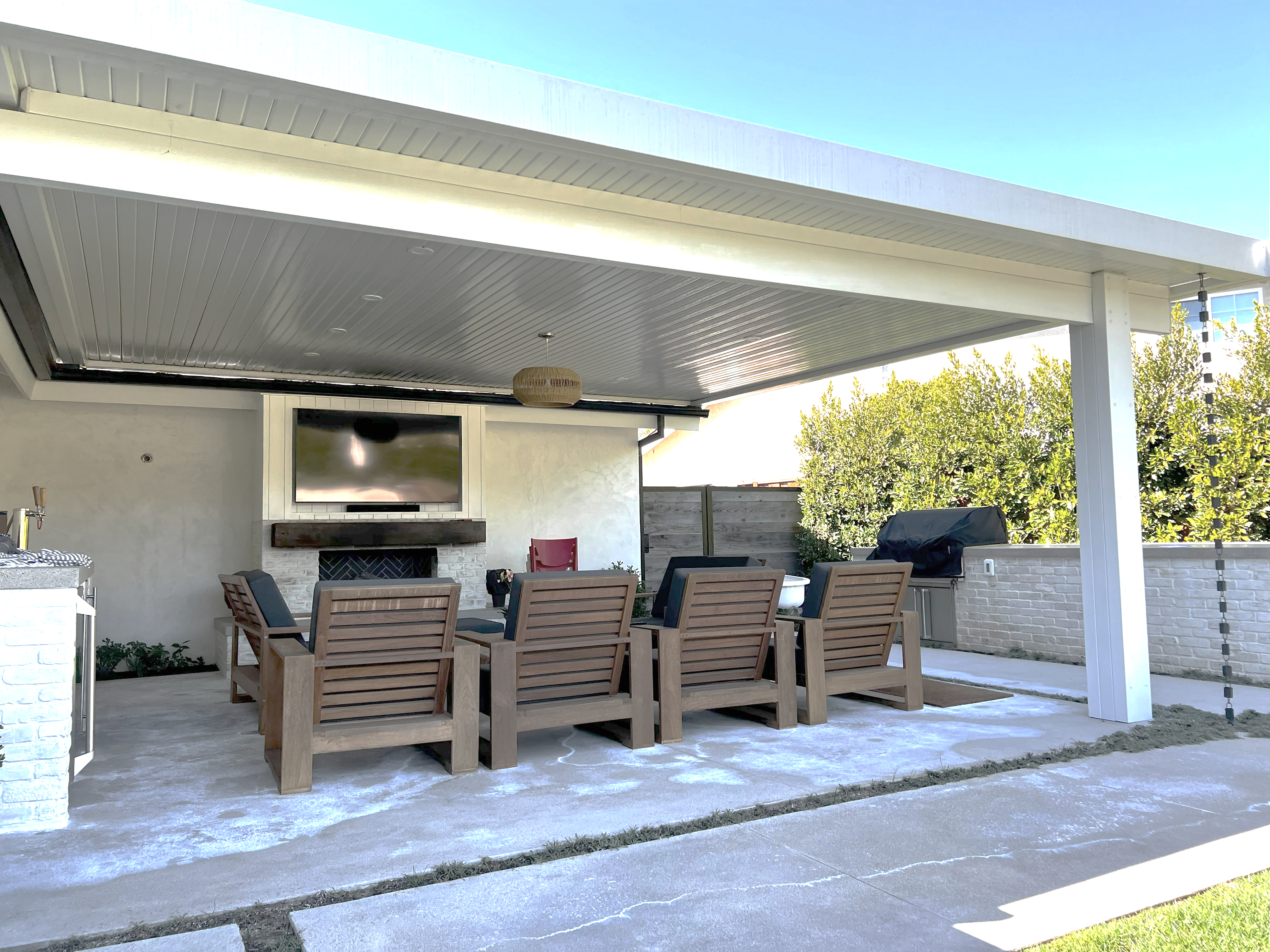 Maxx Panel insulated cover over an outdoor living room with lounge seating and a TV