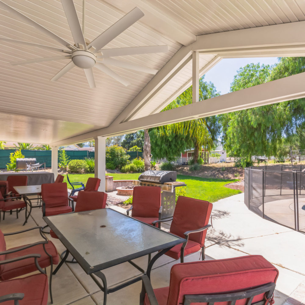 White solid gable cover with ceiling fan over backyard dining