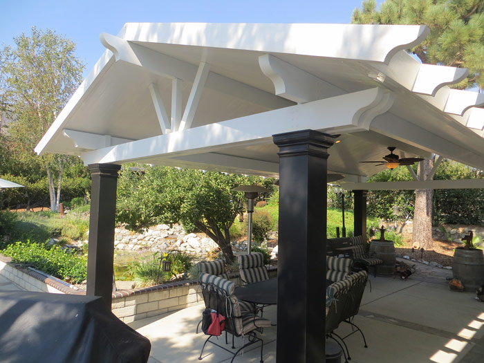 White solid cover with black columns and ceiling fan in a garden