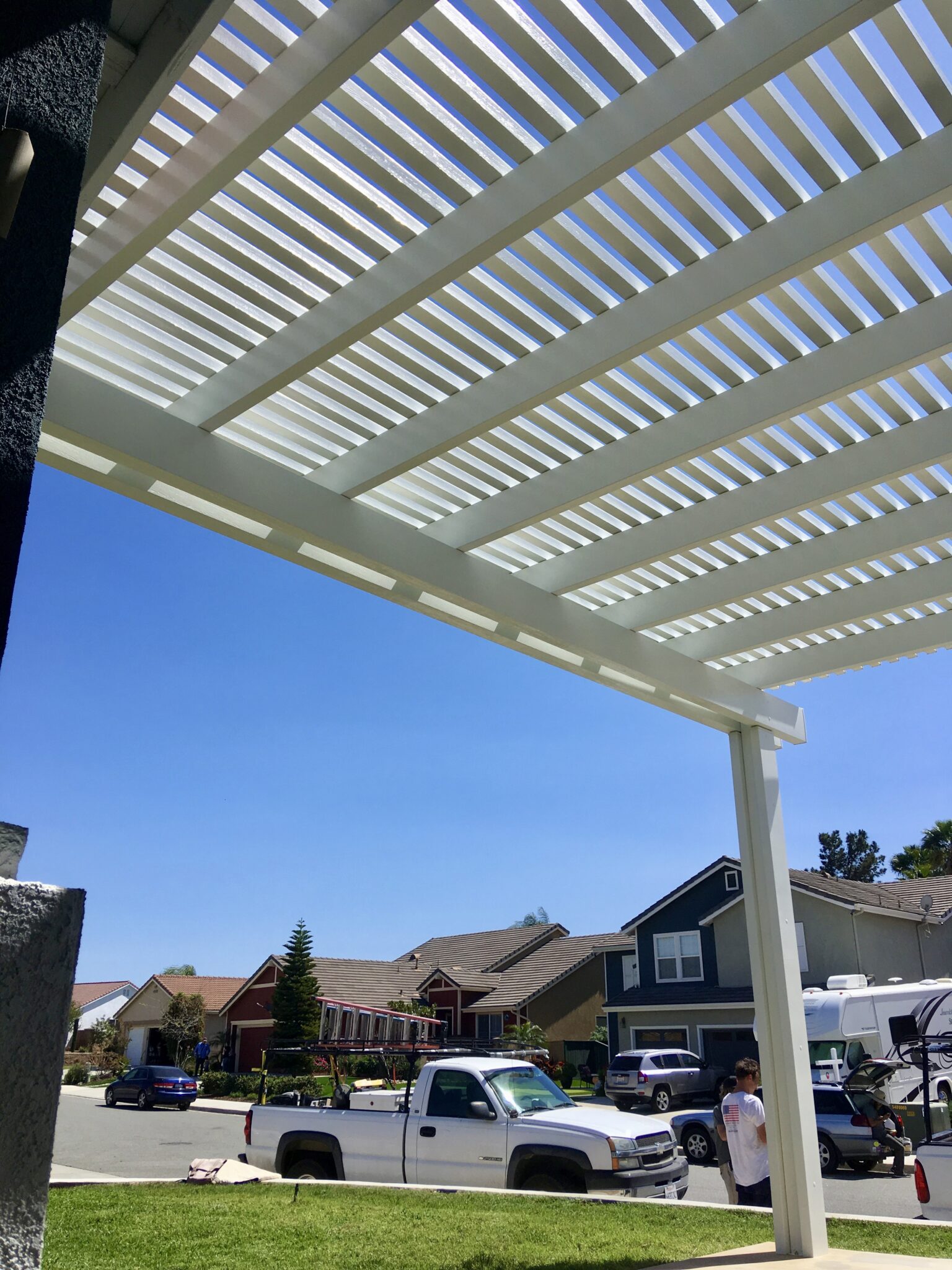 Looking up at the open lattice slats of a Laguna Lattice patio cover against a blue sky