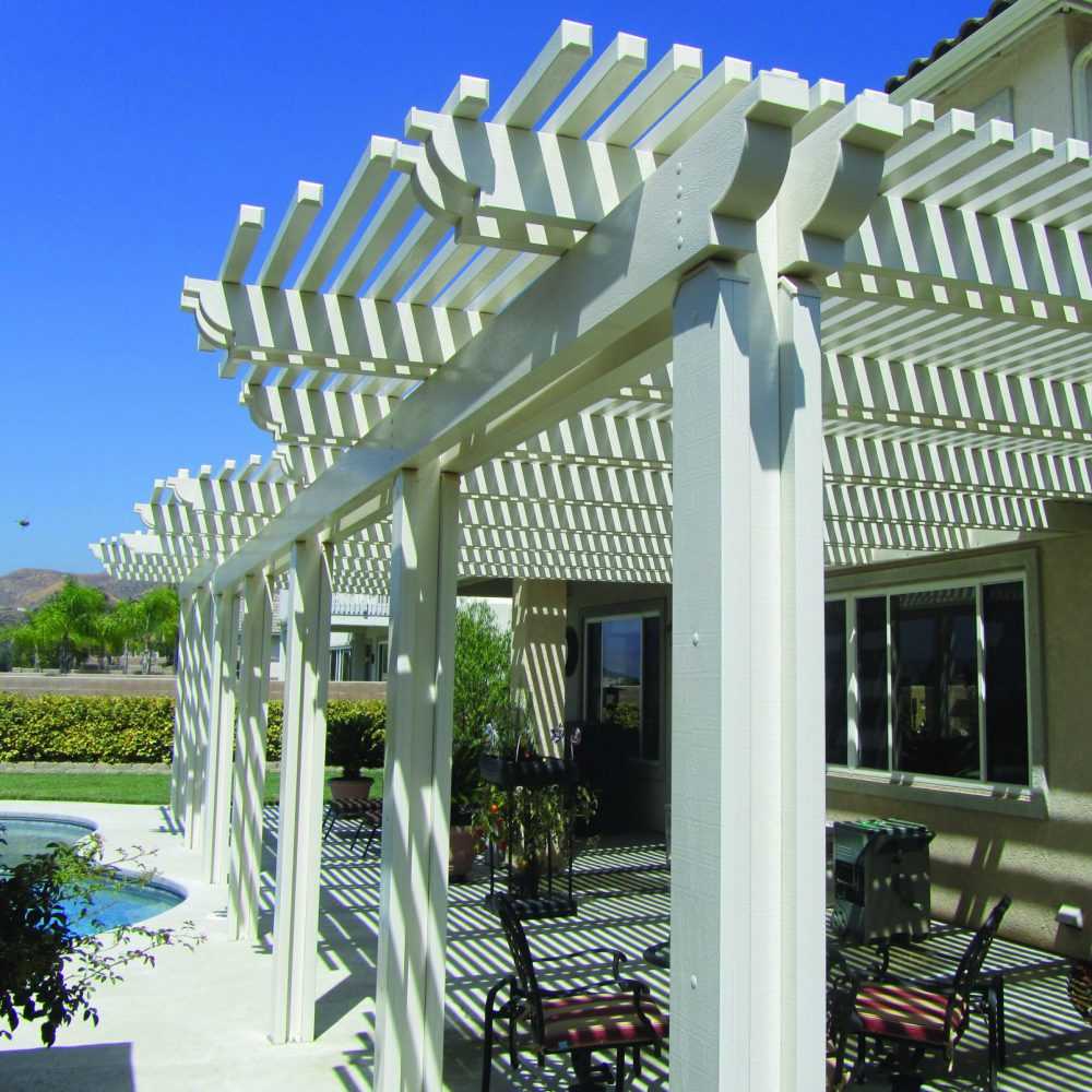White lattice patio cover on Mediterranean home, poolside